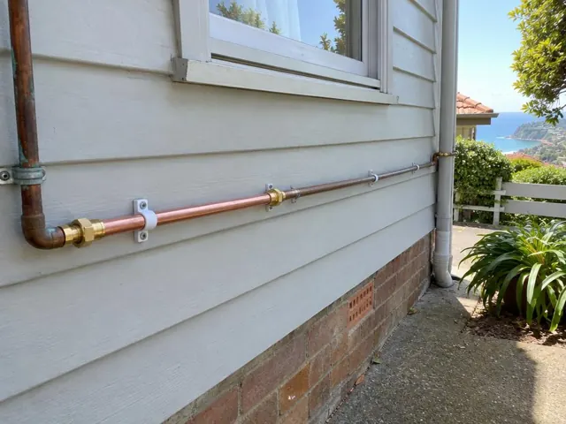 Exterior copper water pipe repair on a weatherboard wall beside a window in Dover Heights